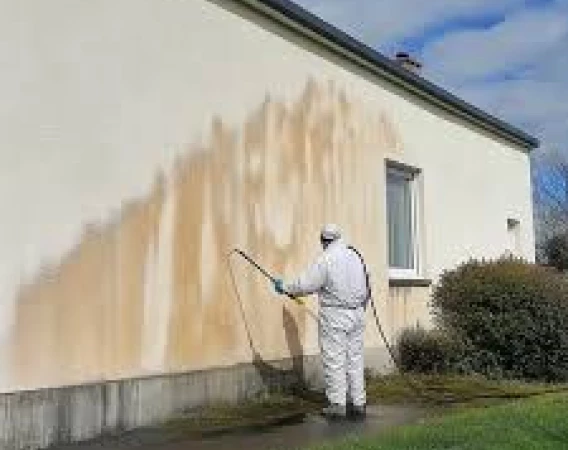 Nettoyage de façade en cours avec pulvérisation produit en Dordogne 24 élimination salissures mur extérieur